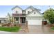 Charming two-story home with a brick and siding exterior, a two-car garage and a well-manicured front yard at 10906 Pastel Pt, Parker, CO 80134