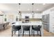 Modern kitchen with a large center island, stylish pendant lights, white cabinets, and stainless steel appliances at 10906 Pastel Pt, Parker, CO 80134