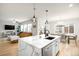 Bright, open kitchen featuring a center island, stainless steel appliances, and seamless transition to the living and dining areas at 10906 Pastel Pt, Parker, CO 80134