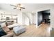 Open-concept living area with wood floors, a large sofa, and seamless flow to the kitchen and adjacent office space at 10906 Pastel Pt, Parker, CO 80134