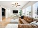 Bright and airy living room with wood floors, a comfortable sectional sofa, and views of the front yard at 10906 Pastel Pt, Parker, CO 80134