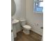 Cozy half bathroom with pedestal sink and wood flooring at 728 N Clubview St, Watkins, CO 80137