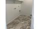 Dedicated laundry room with tile flooring, utility connections, and shelving for added storage at 728 N Clubview St, Watkins, CO 80137