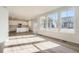 Spacious living room open to kitchen, featuring beautiful hardwood floors and ample natural light at 728 N Clubview St, Watkins, CO 80137