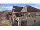 View of the back of the house showcasing a raised deck with stairs and brick pillars at 21753 E Heritage Pkwy, Aurora, CO 80016