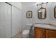 Charming powder room features a wood vanity, framed mirror, and tile flooring at 21753 E Heritage Pkwy, Aurora, CO 80016