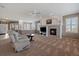 Spacious living room with a fireplace, neutral carpet, and a view of the dining area and front entry at 21753 E Heritage Pkwy, Aurora, CO 80016