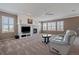 Cozy living room with a fireplace, neutral carpet, bright white trim and large windows with plantation shutters at 21753 E Heritage Pkwy, Aurora, CO 80016