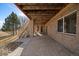 Covered patio area, perfect for outdoor gatherings, with brick pillars and wooden stairs leading to the upper level at 21753 E Heritage Pkwy, Aurora, CO 80016