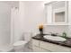 Bright bathroom featuring a vanity with marble countertop, toilet, and a shower behind a white curtain at 2310 Squires Ct, Longmont, CO 80501
