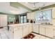 Practical kitchen featuring white appliances, abundant counter space, and a view into the adjacent dining area at 2310 Squires Ct, Longmont, CO 80501