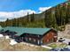 Exterior view of two-story condo building surrounded by trees and mountain in background at 4192 Highway 9 # 3, Breckenridge, CO 80424