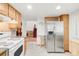 Spacious kitchen with modern stainless steel refrigerator and bar stool, with a view into the living room at 4034 S Atchison Way, Aurora, CO 80014