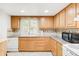 Cozy kitchen featuring light-toned cabinets, granite countertops, and a window with a view of the yard at 4034 S Atchison Way, Aurora, CO 80014