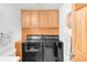 Laundry room with cabinets above black washer and dryer and a door that leads outside at 4034 S Atchison Way, Aurora, CO 80014