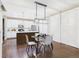 Open concept kitchen and dining area with sleek table and chairs, shutters and modern light fixture at 9236 E 52Nd Dr, Denver, CO 80238