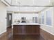 Modern kitchen with white cabinets, stainless steel appliances, large center island, and stylish pendant lighting at 9236 E 52Nd Dr, Denver, CO 80238