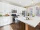 Well-appointed kitchen with white cabinets, stainless steel appliances, and a spacious island with bar seating at 9236 E 52Nd Dr, Denver, CO 80238