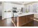 Modern kitchen with white cabinets, stainless steel appliances, large center island, and stylish pendant lighting at 9236 E 52Nd Dr, Denver, CO 80238