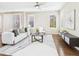Bright living room featuring hardwood floors, large windows with shutters, and a stylish white sofa at 9236 E 52Nd Dr, Denver, CO 80238