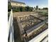 A well-maintained garden area with raised beds and surrounded by a white picket fence, offering a serene outdoor space at 970 Inyokern Ct, Watkins, CO 80137