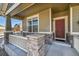 Front door with stone entryway and a white railing at 398 Beldock St, Brighton, CO 80601