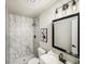 Modern bathroom with marble shower, black fixtures, and a framed mirror at 7870 W 87Th Dr # L, Arvada, CO 80005