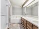 Bathroom features a tub, walk-in shower, and a large vanity with double sinks at 3333 E Florida Ave # 108, Denver, CO 80210