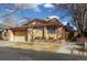 Tan home features an attached two-car garage, manicured front yard, and a brick retaining wall with a red trim at 3333 E Florida Ave # 108, Denver, CO 80210