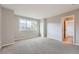 Bright bedroom featuring neutral tones, carpet, large windows, and a doorway to the hall at 19770 E Geddes Pl, Centennial, CO 80016