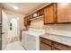 Bright laundry room with ample cabinet storage, white appliances and neutral wall paint and tile flooring at 19770 E Geddes Pl, Centennial, CO 80016