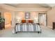 Spacious main bedroom featuring a tray ceiling, and doorway leading to the luxurious en suite bathroom at 19770 E Geddes Pl, Centennial, CO 80016