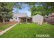Spacious backyard featuring a lush lawn, mature trees, a covered patio, and play equipment at 2965 S Gilpin St, Denver, CO 80210