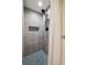 Updated shower with stylish gray tiling, a rainfall showerhead, and a built-in niche for storage at 2965 S Gilpin St, Denver, CO 80210
