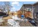 Backyard with a wooden deck, partial snow cover, and a wooden fence at 6521 E 70Th Pl, Commerce City, CO 80022