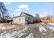 The back of the house and gravel driveway, with partial snow covering at 6521 E 70Th Pl, Commerce City, CO 80022