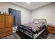 Cozy bedroom with hardwood floors, a metal frame bed and window with a dark curtain at 6521 E 70Th Pl, Commerce City, CO 80022