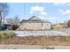 The exterior of the house with a gravel driveway, snow covering, and blue trash bins at 6521 E 70Th Pl, Commerce City, CO 80022