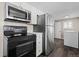 Bright eat-in kitchen features black appliances, lots of cabinets and luxury vinyl plank flooring at 6521 E 70Th Pl, Commerce City, CO 80022