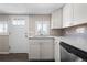 View of the kitchen sink with white cabinets and stainless steel dishwasher at 6521 E 70Th Pl, Commerce City, CO 80022