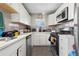 Bright kitchen featuring white cabinets, stainless steel appliances, and ample counter space at 6521 E 70Th Pl, Commerce City, CO 80022