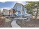 Exterior home view showcasing the upper level balcony, deck, stone patio, and meticulous landscaping at 10040 Longview Dr, Lone Tree, CO 80124