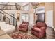 Open-concept living room featuring elegant seating, a cozy rug, and a grand staircase at 10040 Longview Dr, Lone Tree, CO 80124