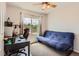 Bright bedroom featuring a comfortable futon, a desk, and a window with scenic neighborhood views at 9651 Bighorn Way, Littleton, CO 80125