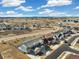 An aerial view shows a community of modern homes with mountain views and open space on a sunny day with blue skies at 1526 Golden Sill Dr, Castle Pines, CO 80108