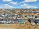 An aerial view showcases a neighborhood with modern homes, well-manicured landscapes, and blue skies with white clouds at 1526 Golden Sill Dr, Castle Pines, CO 80108