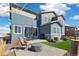 Inviting backyard patio with grill, outdoor furniture, a fire pit, and well-kept synthetic grass at 1526 Golden Sill Dr, Castle Pines, CO 80108