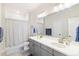 Modern bathroom featuring dual sinks, gray vanity, and a shower with a curtain at 1526 Golden Sill Dr, Castle Pines, CO 80108