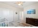 Bright bedroom featuring a crib, dresser, ceiling fan, and wall art, creating a cozy and inviting atmosphere at 1526 Golden Sill Dr, Castle Pines, CO 80108