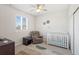 Inviting Bedroom with a gray chair, white crib, neutral walls, and large windows with views of the exterior at 1526 Golden Sill Dr, Castle Pines, CO 80108